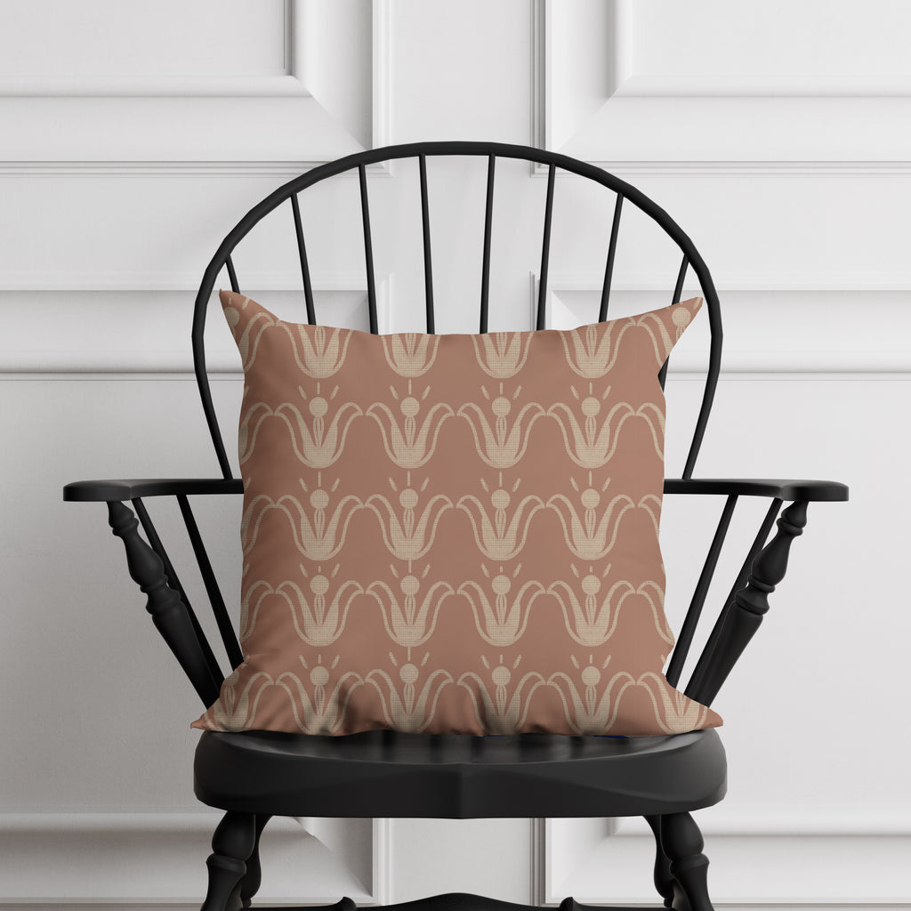 Patterned pillow on a black chair against a white paneled wall