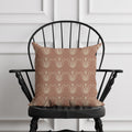 Patterned pillow on a black chair against a white paneled wall