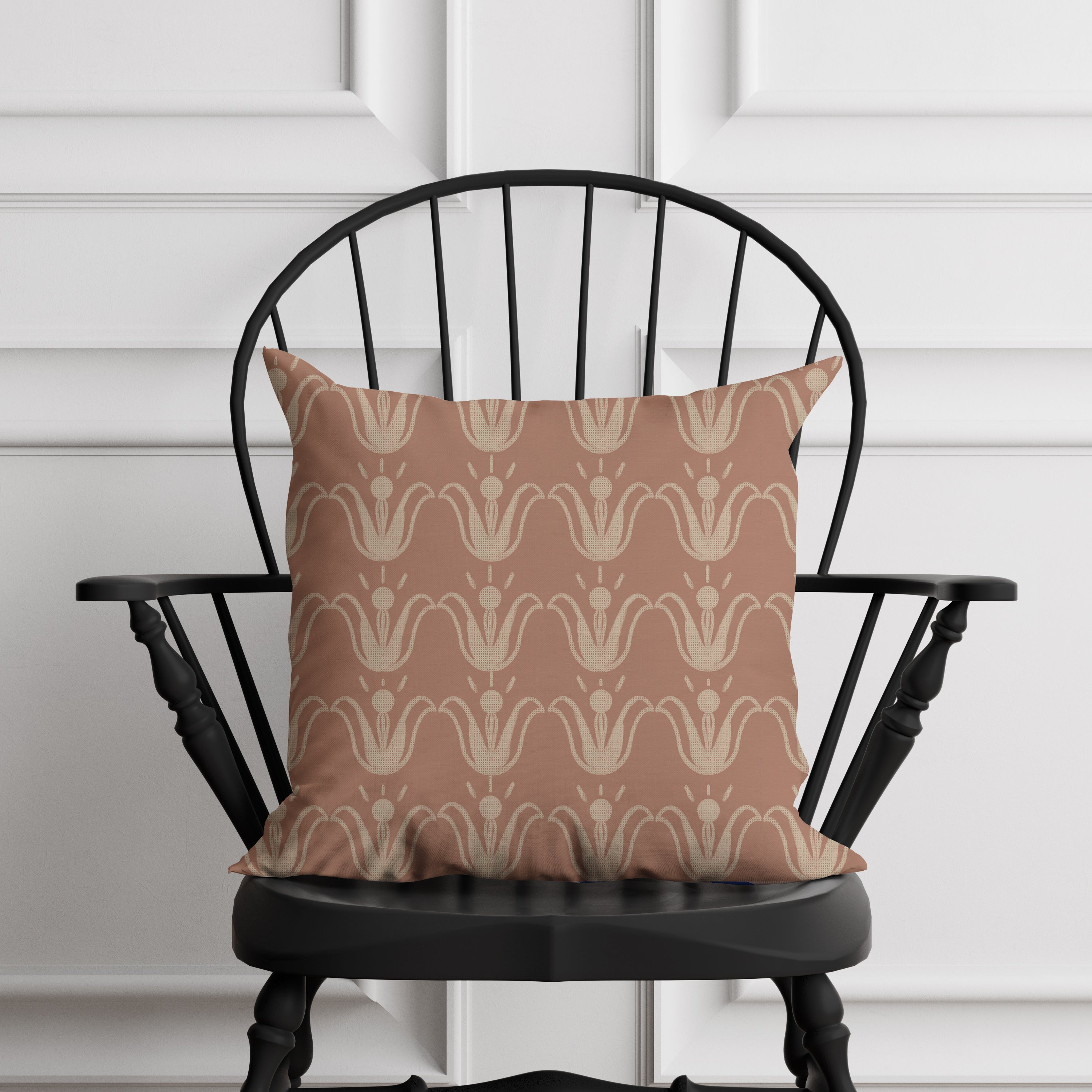 Patterned pillow on a black chair against a white paneled wall