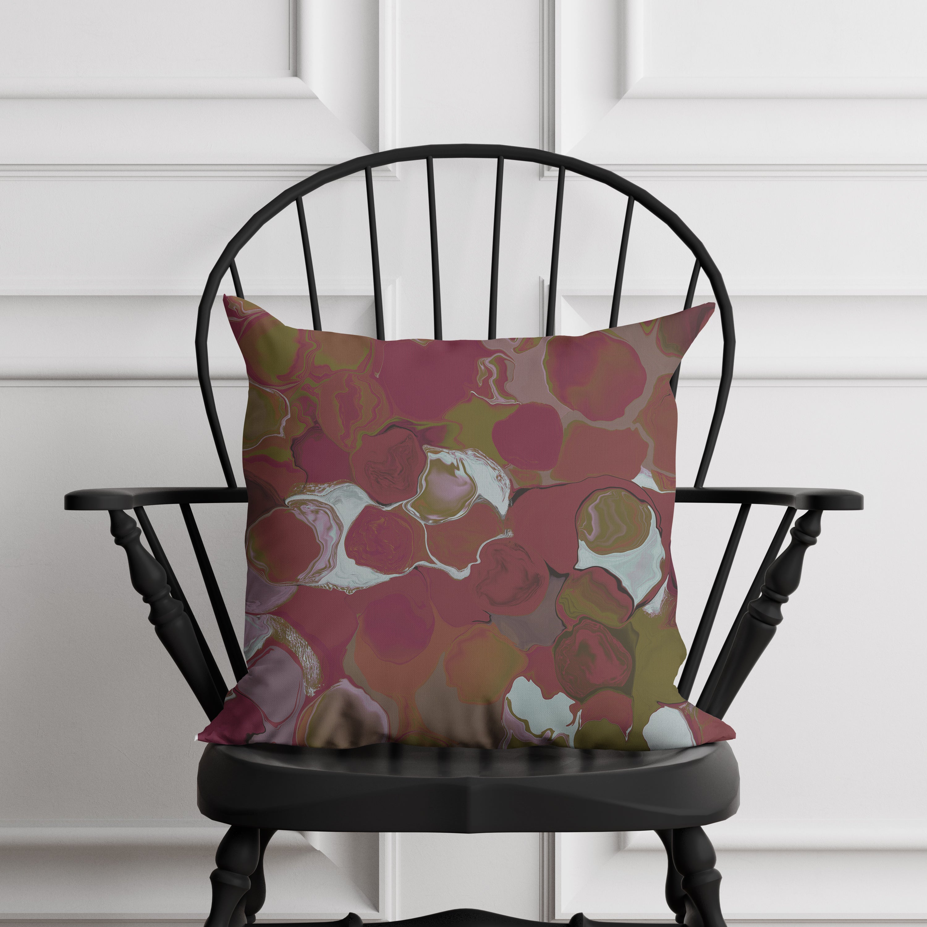 marblized pillow on a black chair against a white paneled wall
