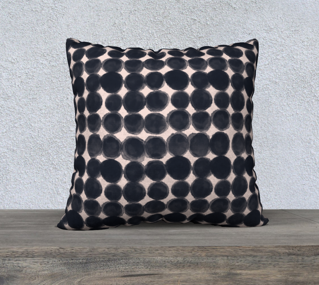 Decorative pillow with black dot pattern on a neutral background