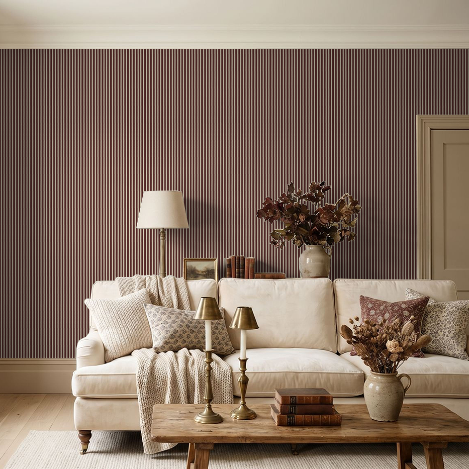 Maroon striped wallpaper in elegant living room with beige sofa and decor.