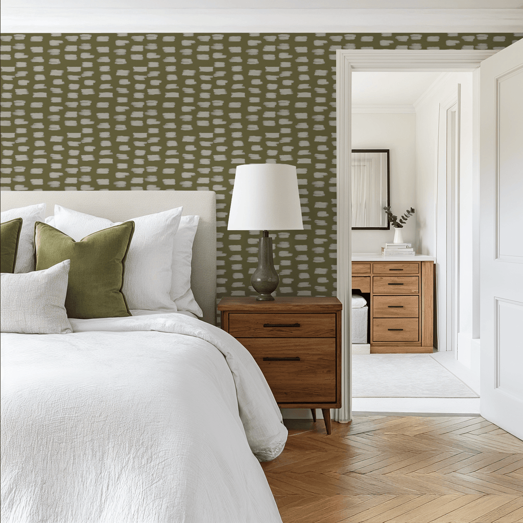Modern bedroom with green patterned wallpaper, wooden nightstand, and bed with white and green pillows.