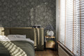 Suzani floral green wallpaper in a cozy bedroom with natural light and blinds.