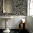 Suzani floral green wallpaper in elegant bathroom with pedestal sink and mirror.